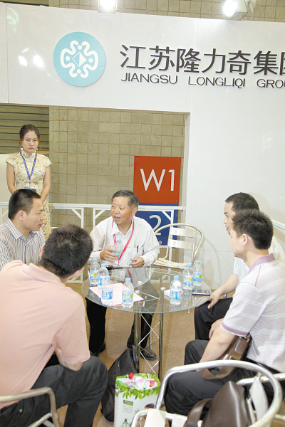 隆力奇总裁徐之伟（中）在美博会现场与客商洽谈